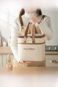 Close-up of beige thermal meal bag with double zippers and wide canvas handle