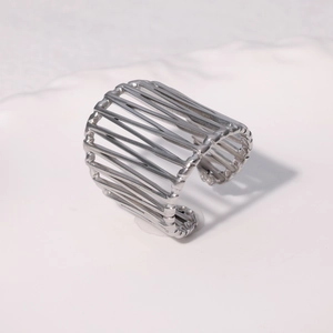 Detailed view of silver stainless steel open bangle with hollow birdcage line pattern