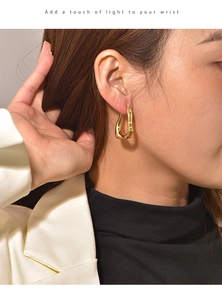Detailed side view of a model wearing minimalist irregular gold earrings in a sleek finish