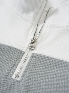 Détail de la fermeture éclair en métal sur polo vintage pour hommes en tissu gaufré