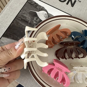 Chic oval pumpkin hair claws in diverse colors including cream, orange, and navy blue