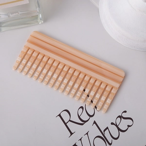 Chic beige striped acetate hair comb with wide teeth for detangling on white tabletop