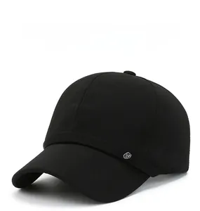Close-up of black baseball cap featuring fine fabric texture and silver metal logo detail