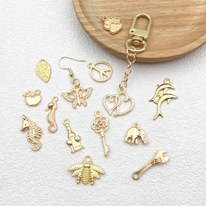 Detailed close-up of KC gold musical note and mermaid charms on a textured white background