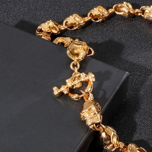 Détail du collier à maillons crâne dorés avec fermoir à bascule OT sur une boîte noire