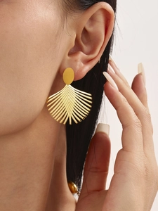 Nahaufnahme goldener Palmblatt-Ohrringe an einem Modell für einen Beach-Stil Look