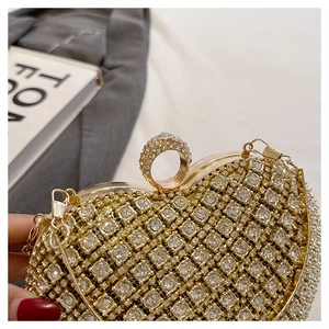 Close-up of heart-shaped gold clutch featuring premium rhinestone inlay and finger ring clasp