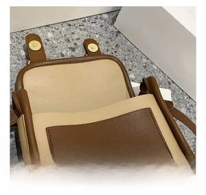 Detail shot of the strong magnetic closure and dual-tone contrast stitching on the flap bag