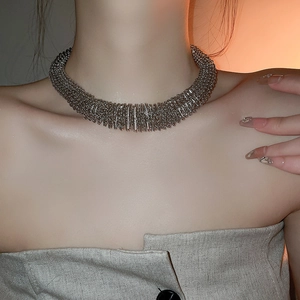 Detailed view of wide silver metallic fringe choker with woven spring texture on model