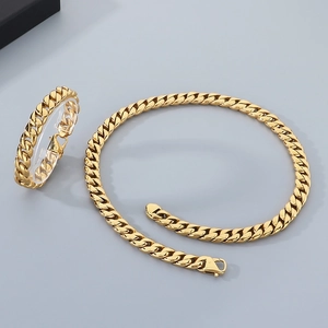 Detailed view of 12mm gold Cuban link necklace and bracelet set on display stand