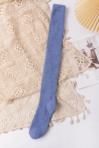 Detailed view of blue coral fleece thigh high socks on lace fabric with cozy lifestyle props