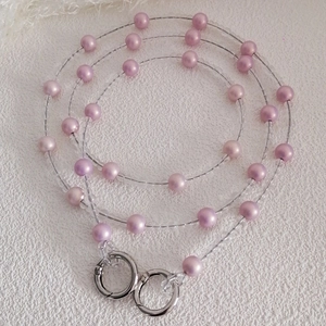 Macro detail of gradient purple bead chain strap with silver metal spring ring buckles