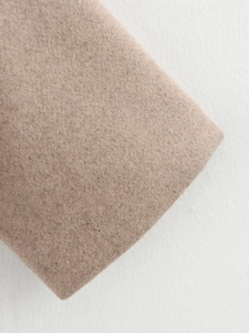 Vue macro du tissu en laine camel montrant une texture douce et un tissage dense