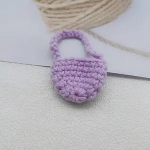 Dettaglio di una mini borsa a cuore fatta a mano all'uncinetto color viola