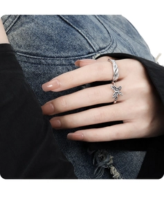 Detail of silver butterfly rings with textured wave band on a model hand