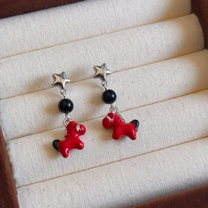 New Chinese style earrings featuring red pony charms and silver star studs on beige fabric