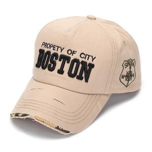Detailed embroidery on a beige distressed baseball cap with camo under-brim texture