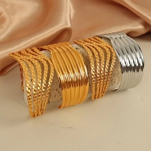 Modern geometric wavy open cuff bracelets in gold and silver finish with vertical texture