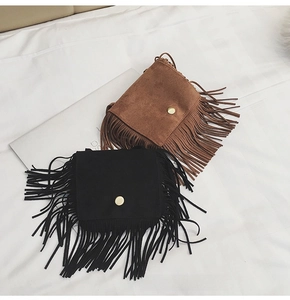 Detailed view of matte faux suede crossbody bags with long fringe and gold magnetic clasps