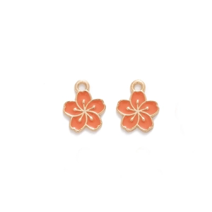 Detail of two coral pink enamel cherry blossom pendants with golden alloy edges