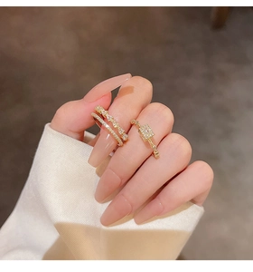 Detail of gold double-layer diamond ring and square zircon ring on finger