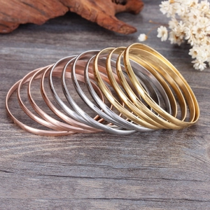 Polished minimalist stainless steel bangles in gold, silver, and rose gold finishes