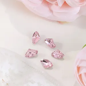 Macro shot of 6x10mm pink faceted nail crystals D089 with elegant floral background