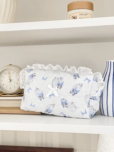 Quilted white cotton storage bag with blue cat print and white lace trim in a home setting