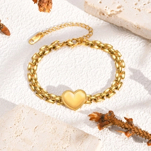 Detail of gold stainless steel heart charm bracelet with flat curb links and lobster clasp