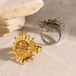 Macro shot of gold and silver sun god face relief rings on a stone surface