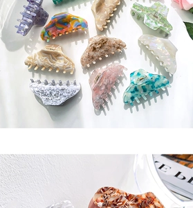 Macro detail of glossy acetate hair claw clips in various vibrant colors for women