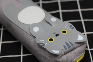Detail of grey cat canvas pencil case showing cat face patch and yellow zipper