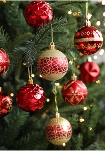 Detailed view of red and gold Christmas ball ornaments with intricate textures on a tree