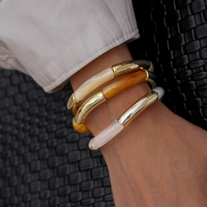 Close-up of three-piece stretch bracelets with acrylic resin and gold metal tubes