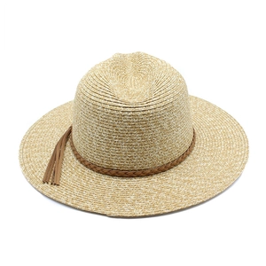 Close-up of straw Panama hat featuring a brown braided leather band and tassel detail