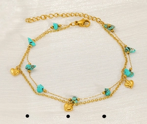 Close-up of double-layered golden stainless steel anklet with turquoise and heart pendant
