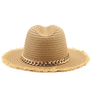 Close-up of wide-brimmed raffia sun hat with raw edges and chunky gold chain detail