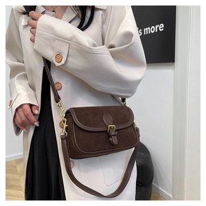 Model view of dark brown suede crossbody bag with vintage buckle and leather strap