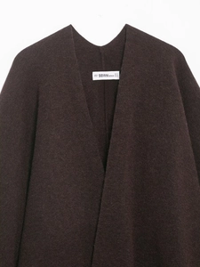 Close-up of knit poncho jacket showing neckline detail and soft wool fabric texture