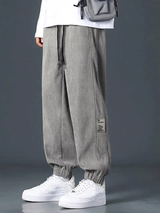 Detail of grey corduroy joggers with adjustable drawstring waist and side cargo pockets