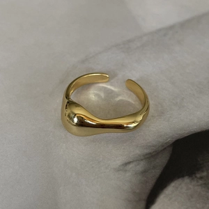 Détail de la bague irrégulière en argent 925 dorée, design ondulé minimaliste