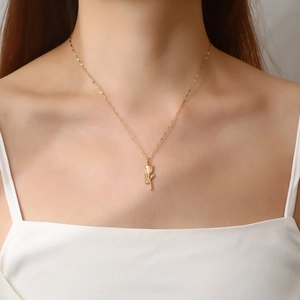 Detail of vintage gold rose pendant necklace worn by model showing intricate petal texture