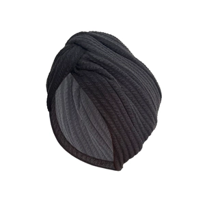 Thick stretchy turban hat with cross-twist design in black ribbed knit fabric