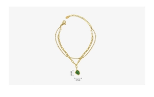 Detail of gold double-layer bracelet with emerald acrylic geometric pendant and lobster clasp