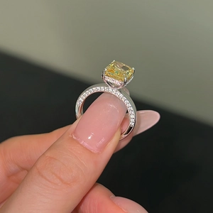 Close-up of radiant yellow ice-cut zircon ring with micro-pave silver setting