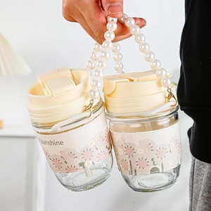 Dual-drink glass tumbler with pearl handle and floral sleeve for stylish hydration