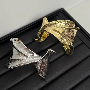 Detailed macro view of gold and silver wide cuffs with irregular hammered metal texture