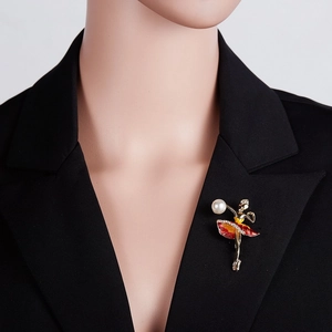 Detail of ballet dancer brooch with red enamel skirt and pearl on black blazer lapel