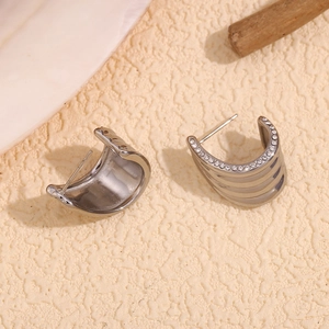 Macro shot of silver C-shaped wide hoop earrings with sparkling white cubic zirconia