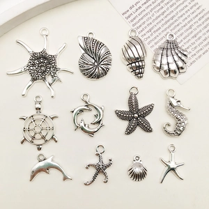 Detailed close-up of 11 antique silver marine charms including starfish, shells and sea life